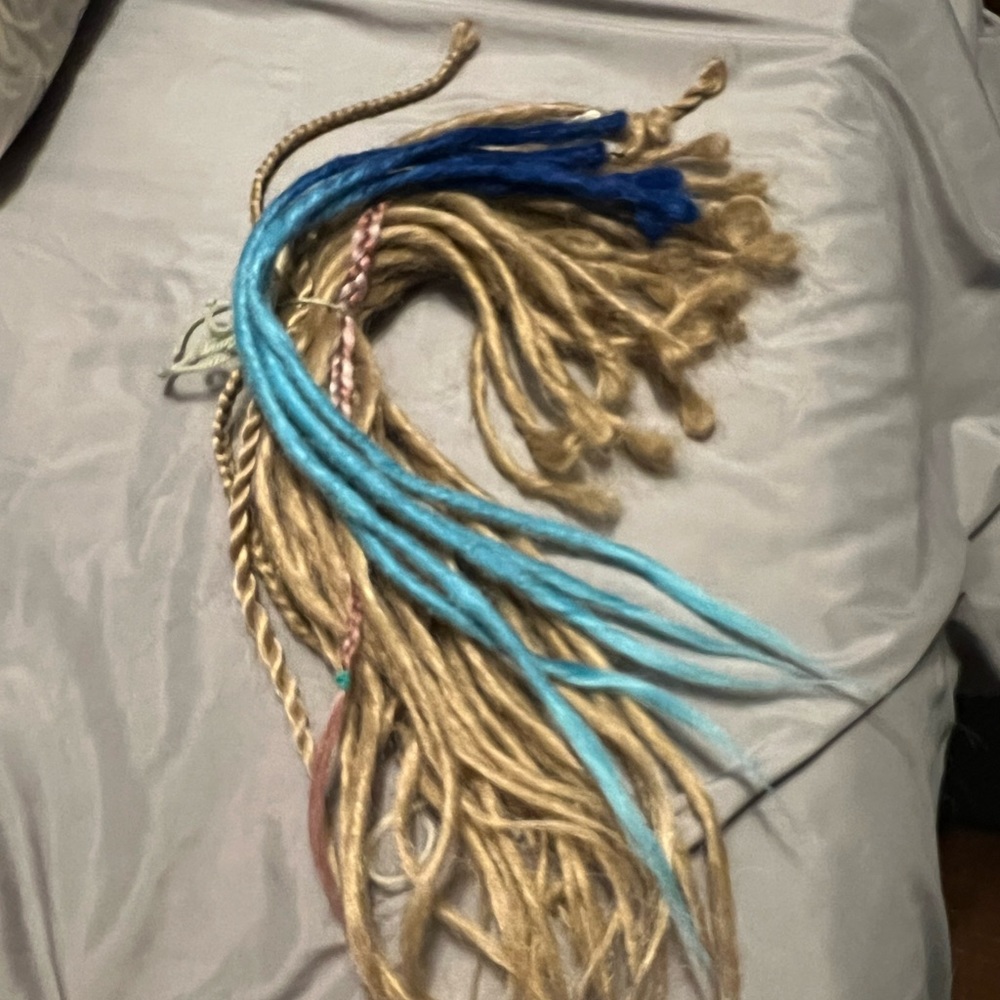 25 Dark blonde dreads with 5 blue dreads and 4 braids.